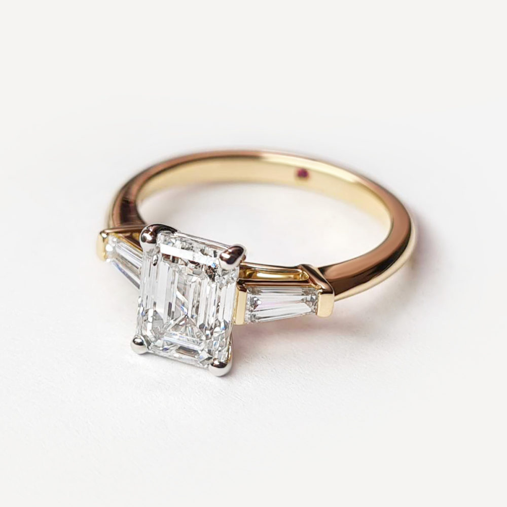 Yellow gold trilogy emerald and tapered baguette diamond engagement ring
