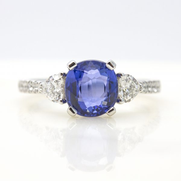 cushion cut blue sapphire with heart diamond accent stones and pave diamond engagement ring