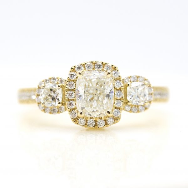 cushion cut diamond diamond halo trilogy engagement ring in yellow gold
