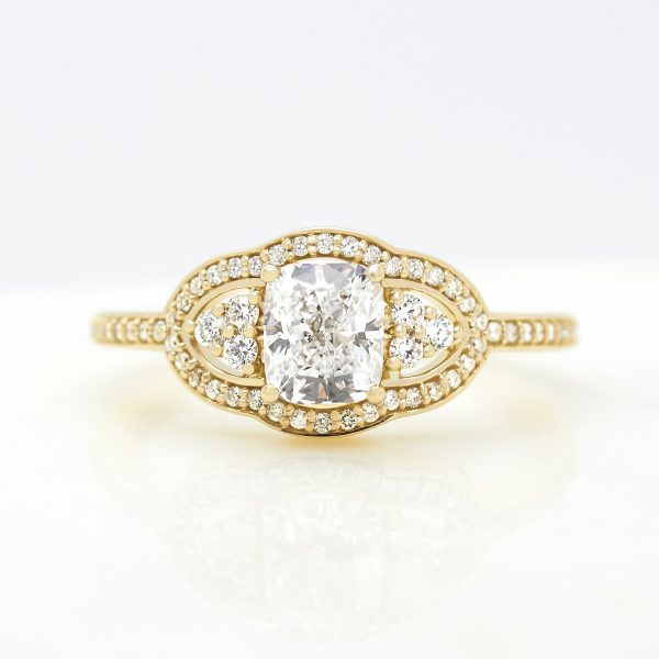 elongated cushion diamond trilogy engagement ring bead set diamond halo and band set in yellow gold