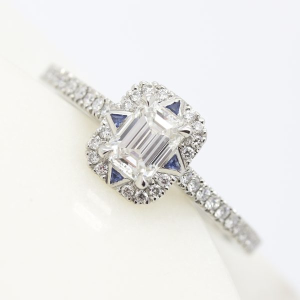 emerald cut diamond halo engagement ring with trillion blue sapphires