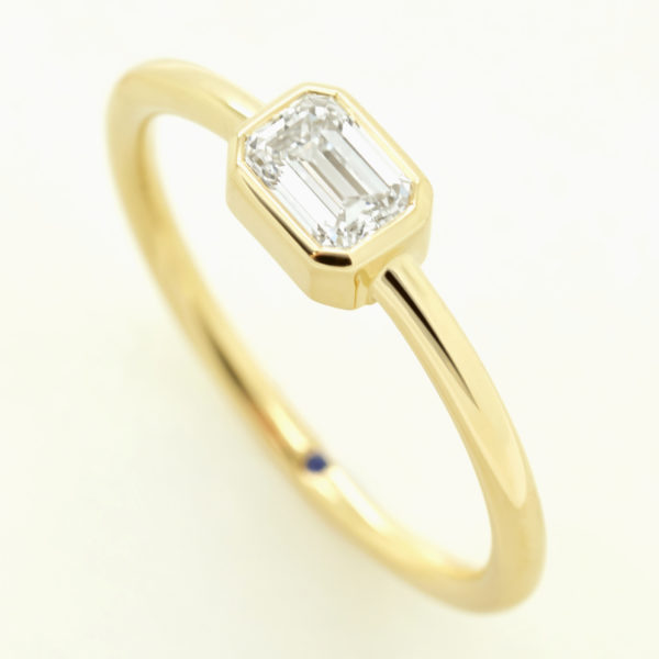emerald diamond bezel set yellow gold