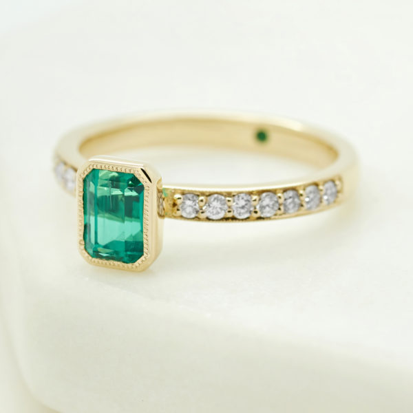 Vintage emerald yellow gold engagement ring with channel set diamond band