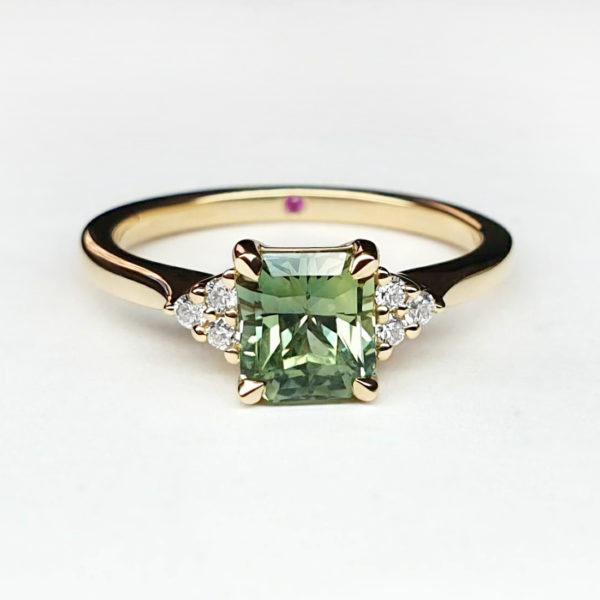 Green sapphire set in yellow gold with round accent diamonds