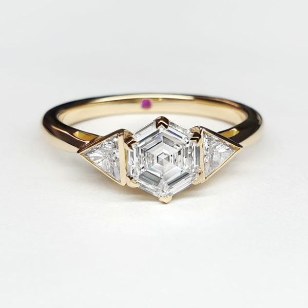 Hexagonal diamond set with trilliant accent diamonds, set in yellow gold