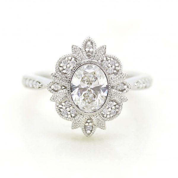 oval centre diamond engagement ring with milgrain bead set halo detail