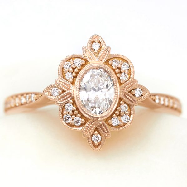 vintage oval diamond rose gold engagement ring with accent diamonds and milgrain detail