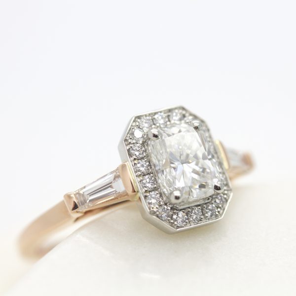 trilogy engagement ring with radiant cut with diamond halo and tapered baguettes set in platinum and rose gold