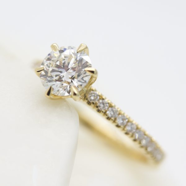 round diamond and pave band in six claw yellow gold setting