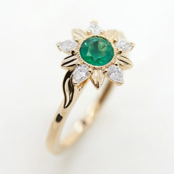 round emerald organic engagement ring with diamond floral halo in yellow gold
