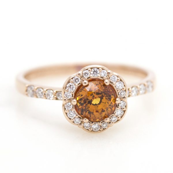 round orange sapphire with diamond halo set in rose gold