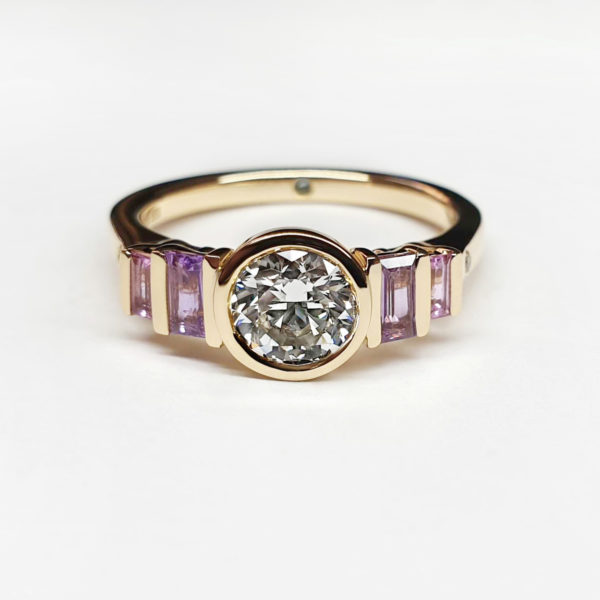 round brilliant diamond set in yellow gold with purple sapphires