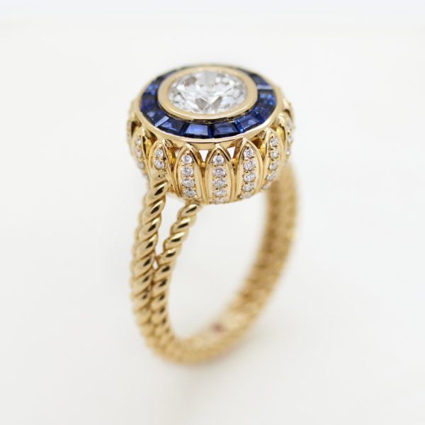 Vintage round diamond yellow gold engagement ring with a sapphire halo and a diamond petal shaped basket - in the style of Mary Kate Olsen's engagement ring