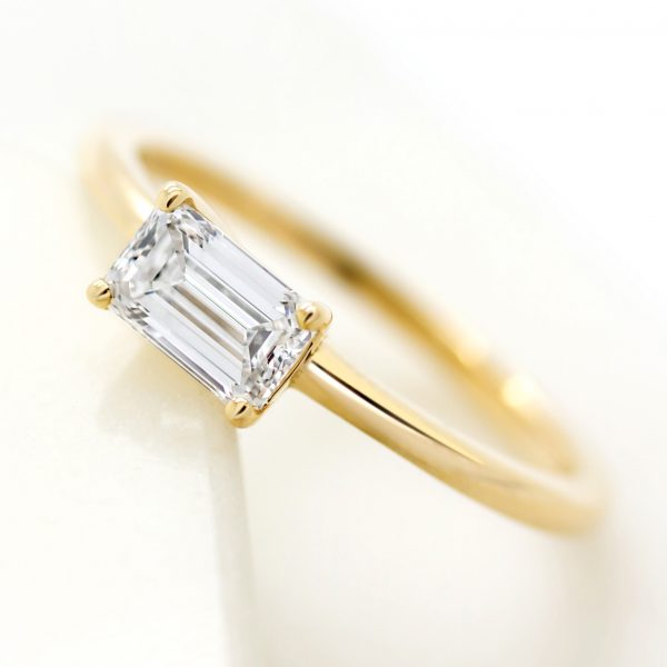 unique yellow gold engagement ring set with east west emerald diamond