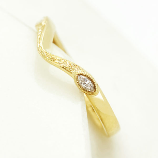 Vintage engraved yellow gold wedding band with a marquise diamond